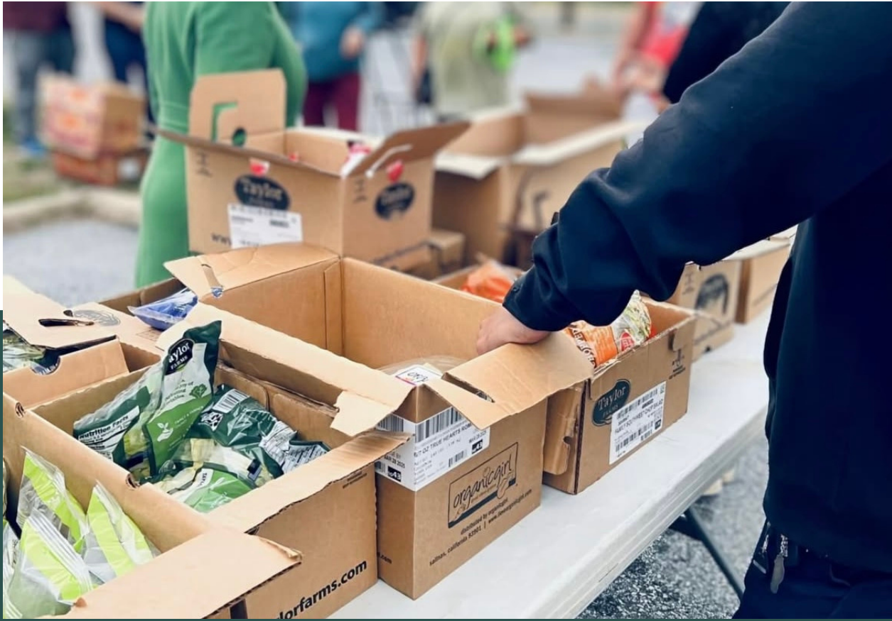 Volunteers packing boxes of fresh produce at a community distribution event