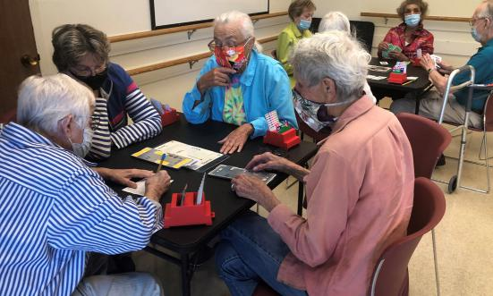 A group of seniors playing a card game together at a table.