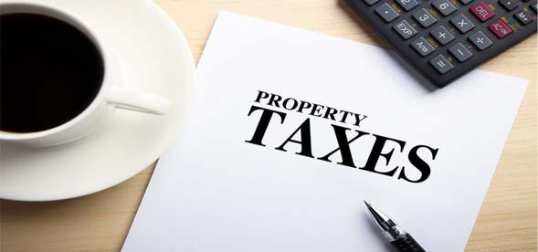Property taxes document with a pen, cup of coffee, and calculator