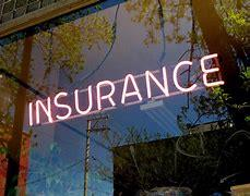 Neon insurance sign glowing in window reflection