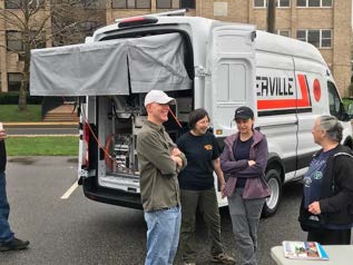 Municipal utility crew gathered next to a service van
