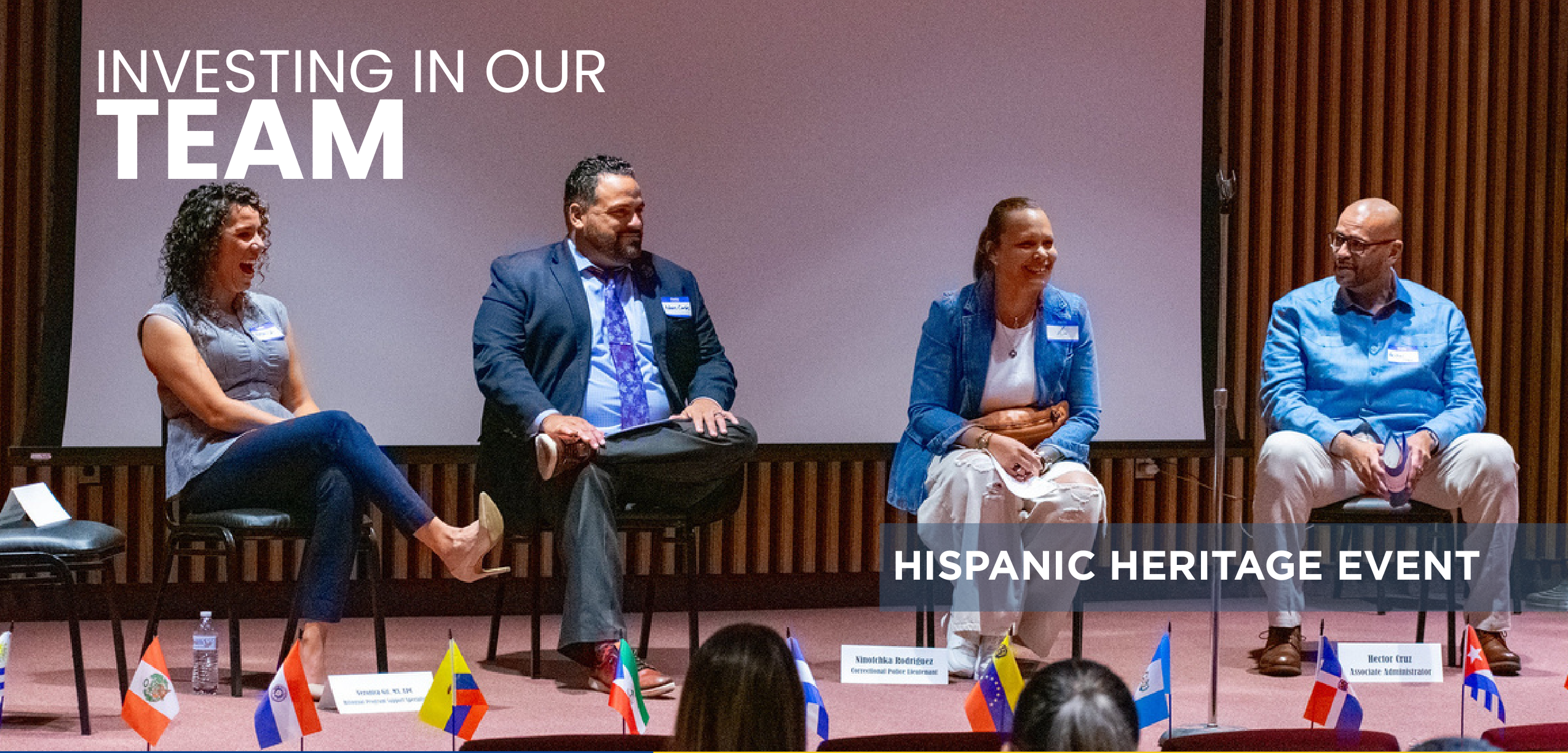 Panel discussion on stage during the Hispanic Heritage Event with four speakers seated in chairs