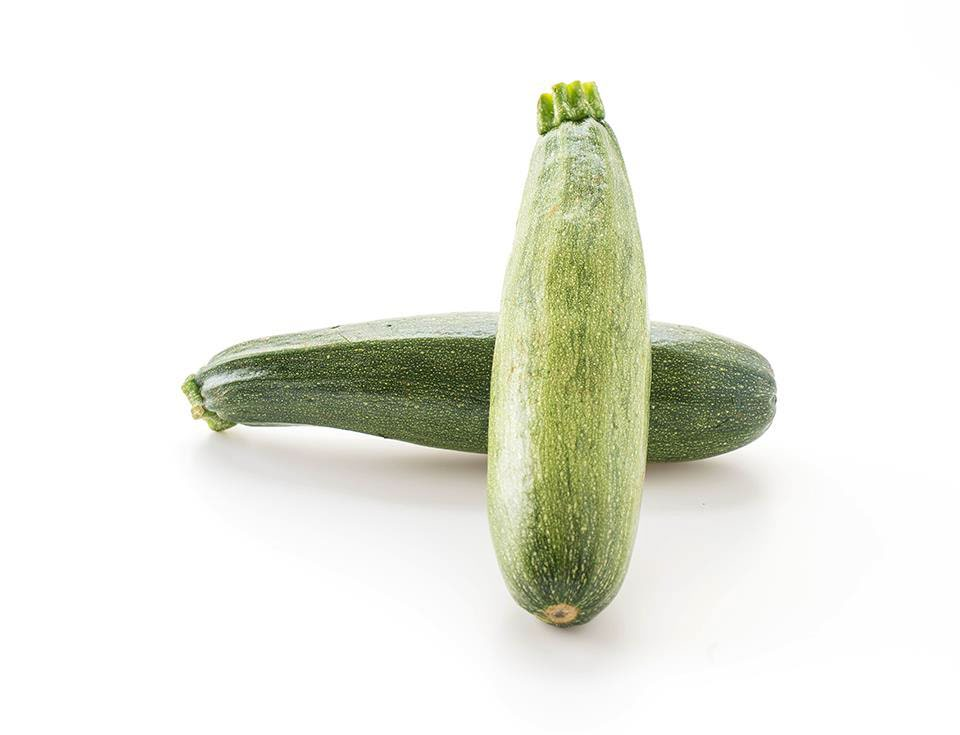Two fresh green zucchinis stacked crossed on a white background