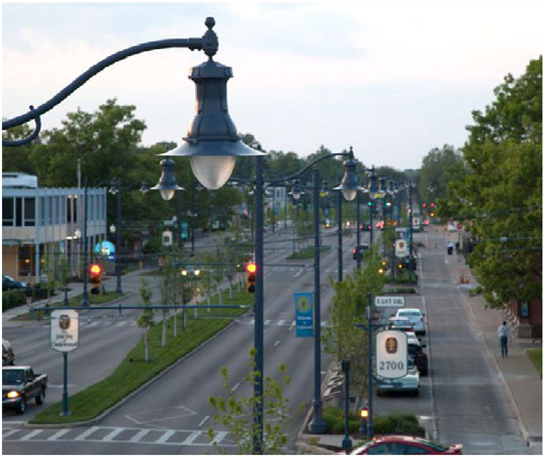 Far Hills Avenue thoroughfare in Oakwood lined with ornamental streetlights, landscaped medians, and vehicles in transit
