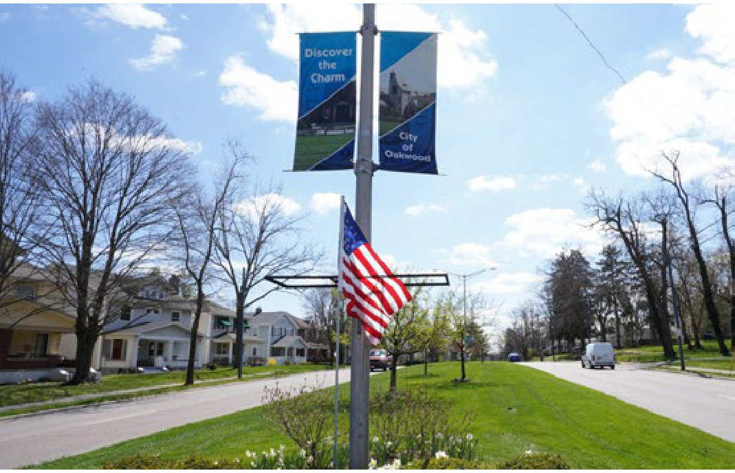 Boulevard in Oakwood featuring a decorative light pole with 'Discover the Charm / City of Oakwood' banners and an American flag.