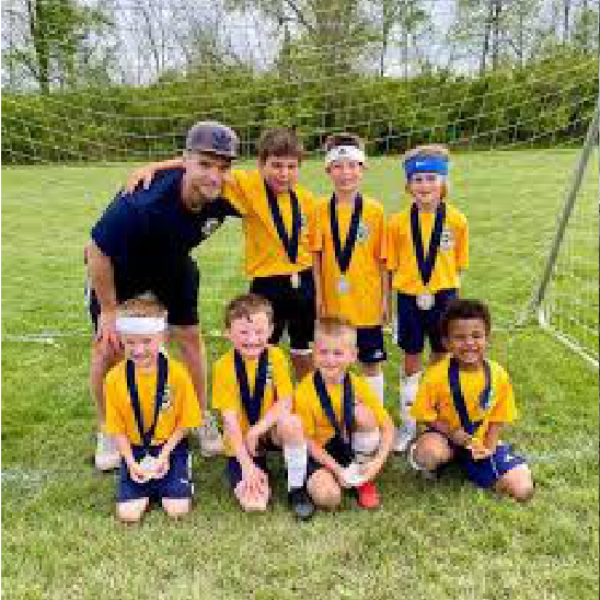 Youth soccer players with medals and coach