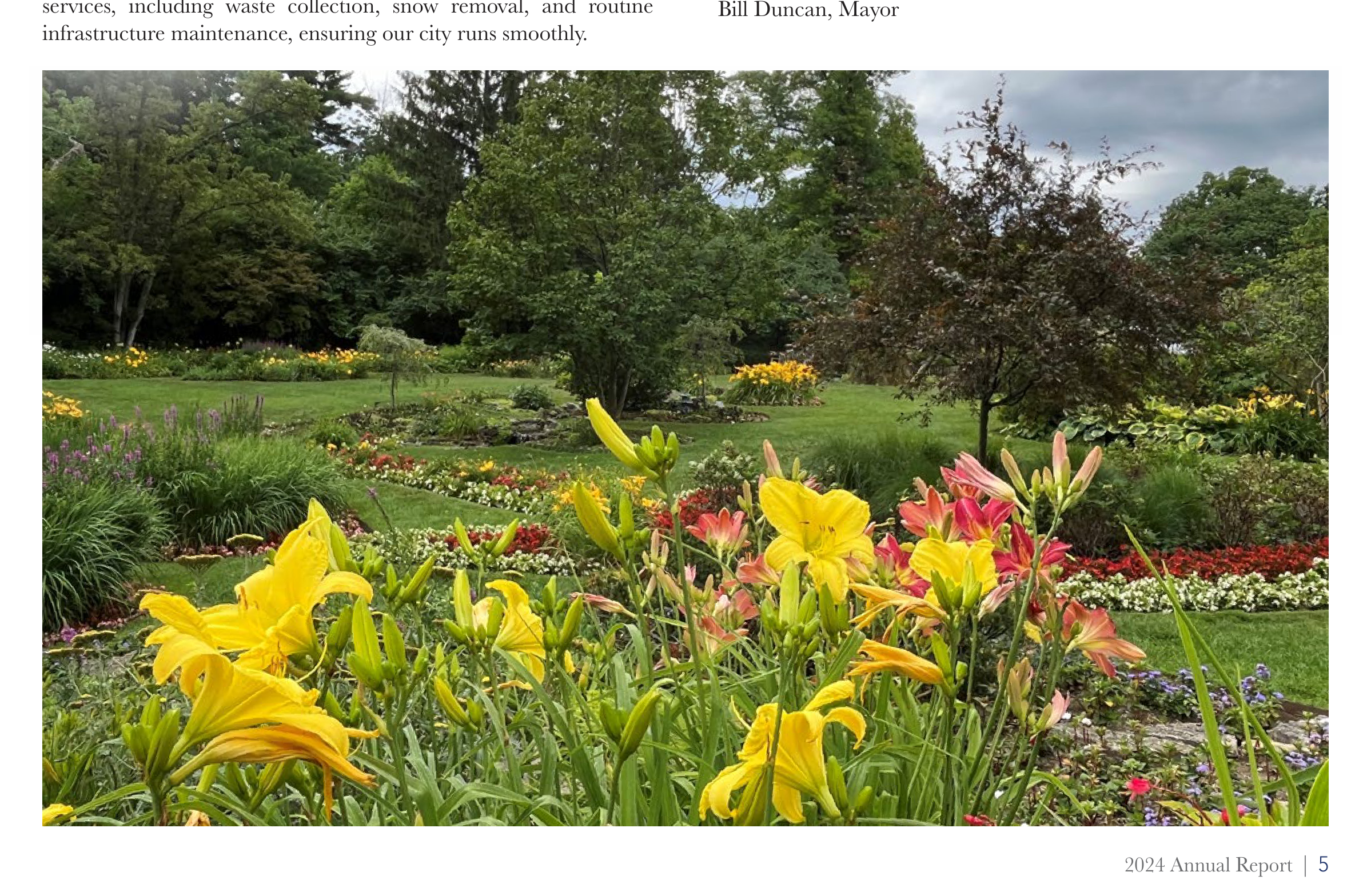 Lush garden landscape in Oakwood park featuring vibrant yellow daylilies in the foreground and landscaped flowerbeds