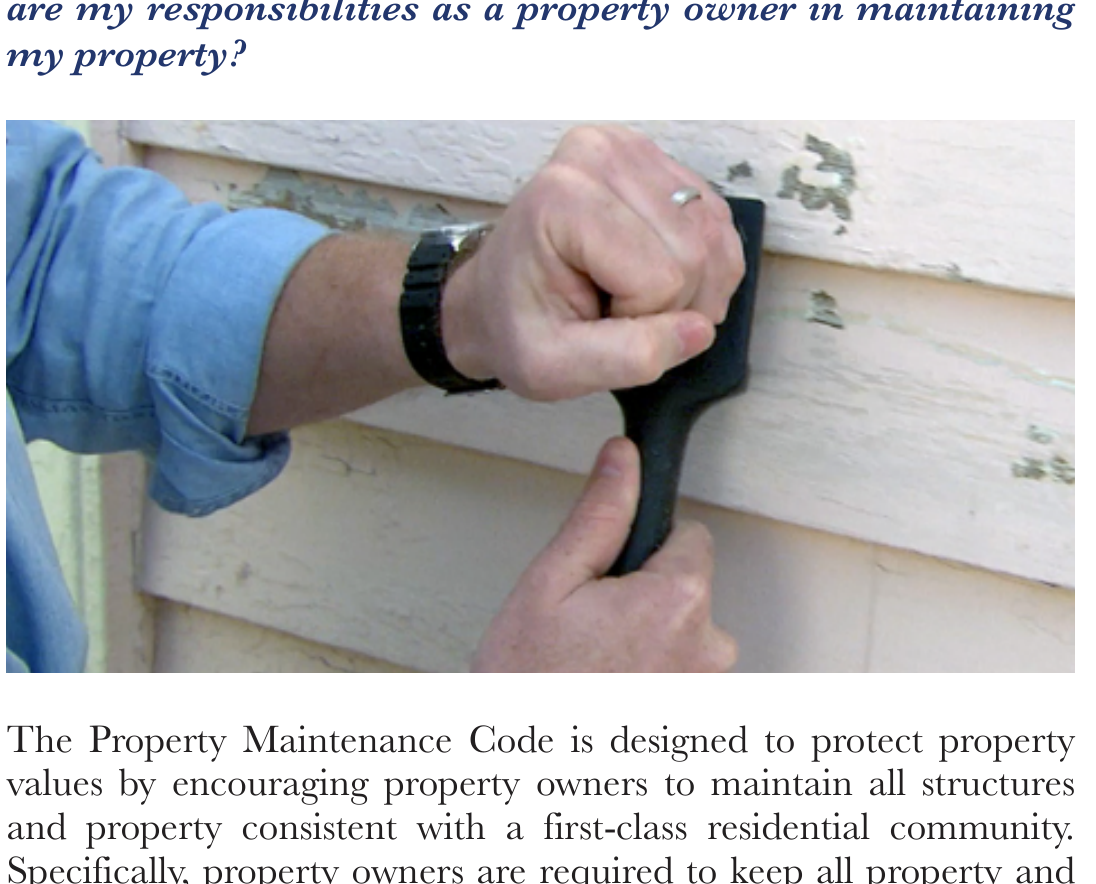 Worker using a scraper tool to remove peeling paint from residential wood siding