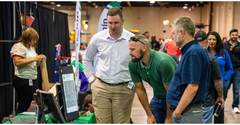 ODOT staff and attendees interacting at a conference booth with computer displays
