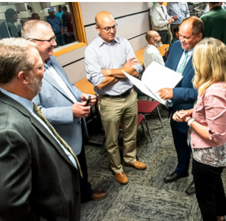Group of professionals gathered reviewing documents and schematics