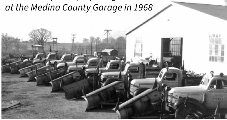 Historical black and white photograph of state snow plows lined up at the Medina County Garage in 1968