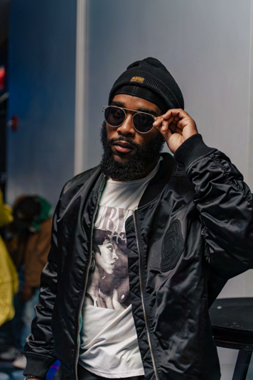 Jabz York wearing black beanie, sunglasses and jacket, adjusting glasses