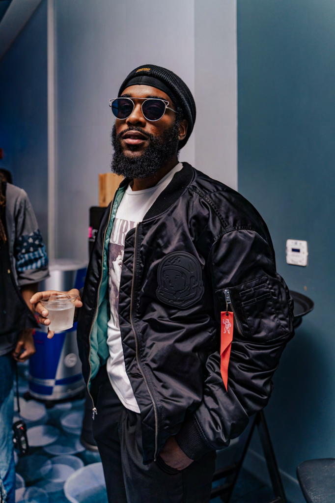 Jabz York wearing sunglasses and black jacket, holding drink