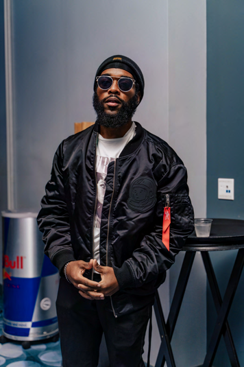 Jabz York standing with hands clasped in front, wearing sunglasses and black jacket