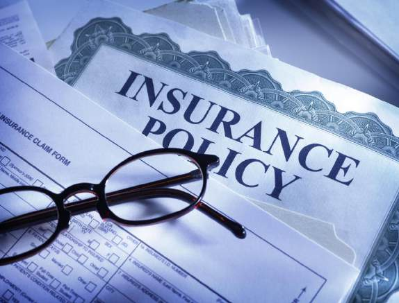 Insurance policy document with claim form and reading glasses