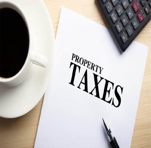 Property taxes document with cup of coffee, calculator, and pen