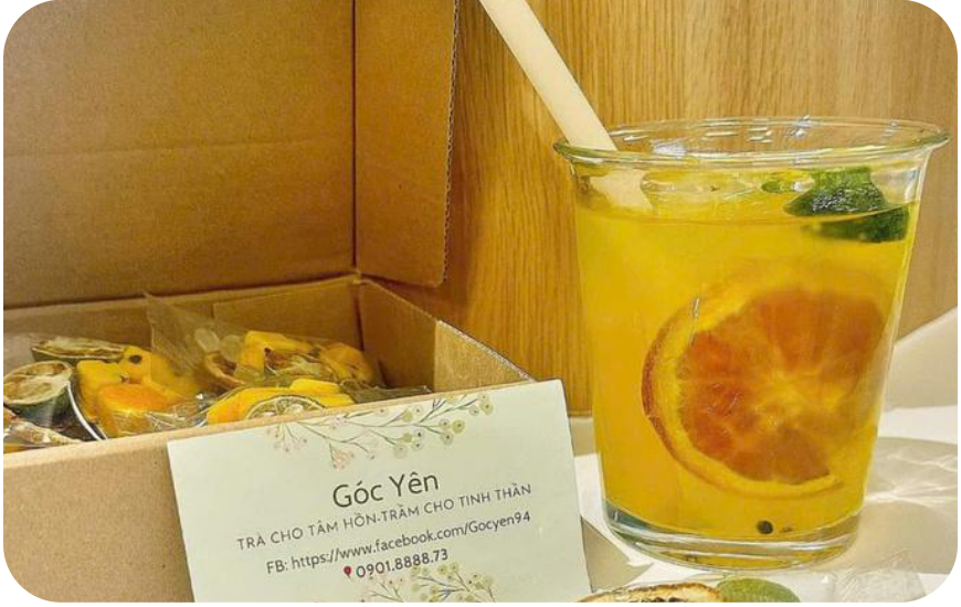 Glass of cold passion fruit tea next to a Góc Yên business card