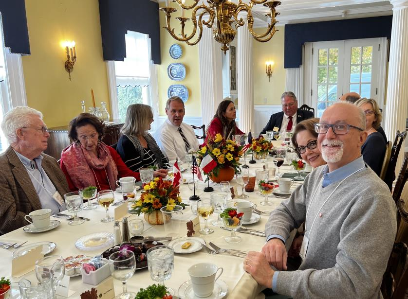 Guests enjoying lunch at a long dining table with floral centerpieces