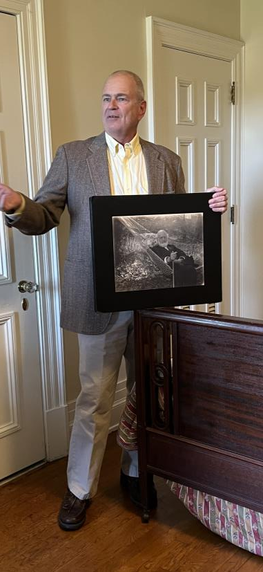 A speaker holding a framed historical photo