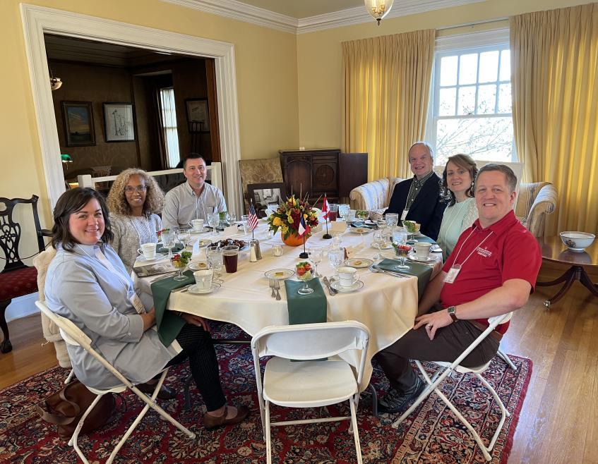 Guests gathered at a dining table in a bright room