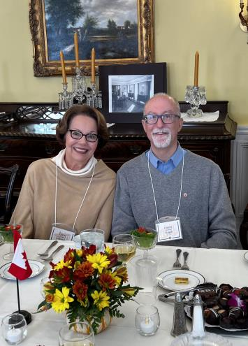 A couple smiling at a dining table with Canadian flag decor