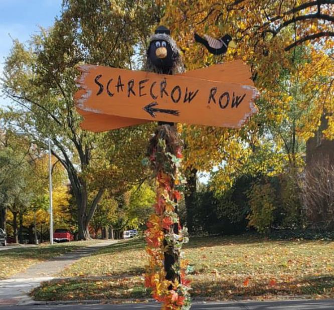 Scarecrow Row directional sign decorated with fall foliage