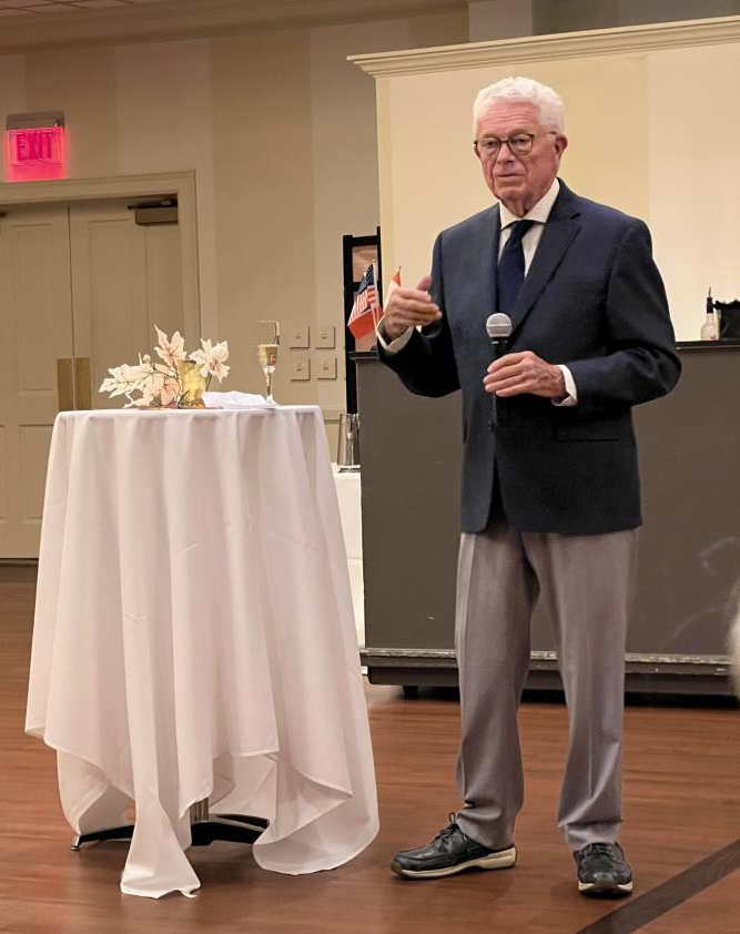 Speaker giving welcome remarks at high cocktail table