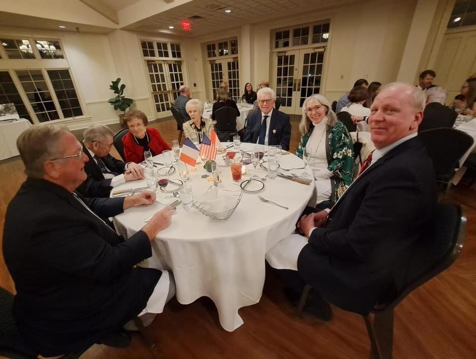 Guests seated at round dining table with international flags