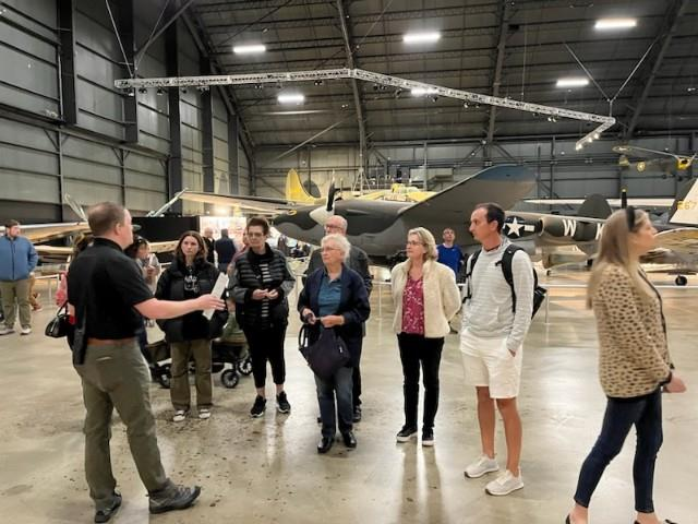 Group listening to tour guide in aircraft hangar