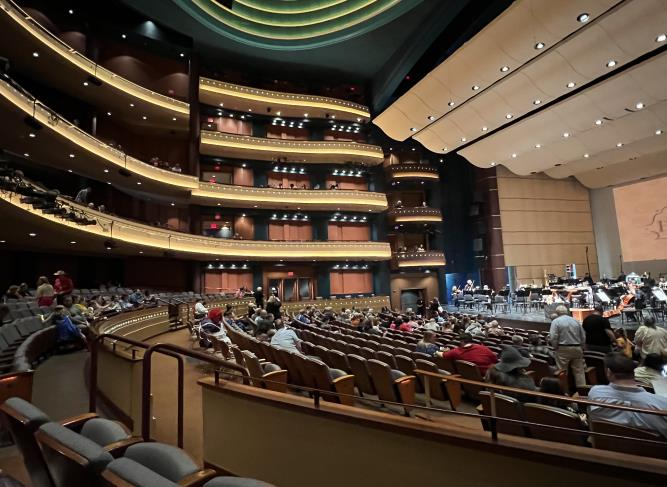 Audience members seated inside the grand Schuster Center theater hall
