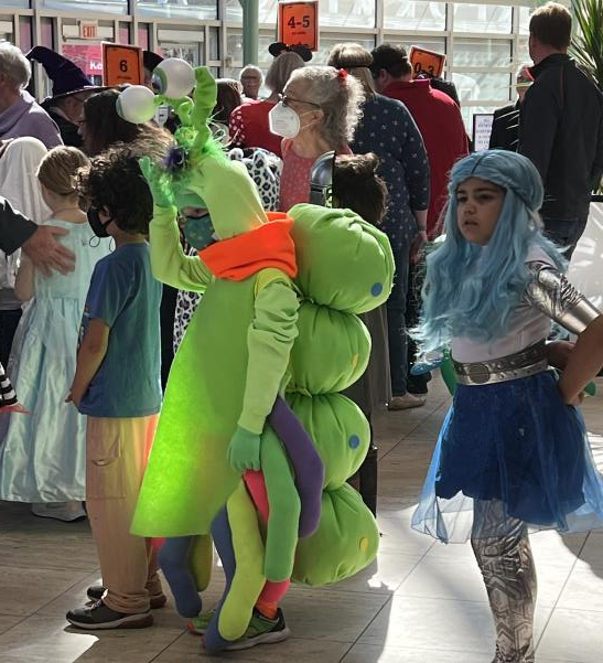 Attendees and children in creative Halloween costumes in the lobby