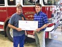 New Jersey American Water representative presenting a donation check to a Scullville Volunteer Fire Department firefighter in front of a fire engine