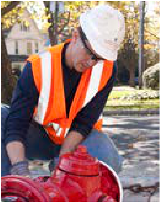 Utility technician inspecting a red fire hydrant