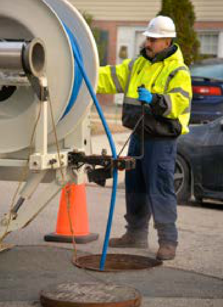 Utility worker operating maintenance equipment