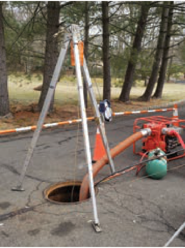 Tripod safety hoist system deployed over a sewer maintenance hole