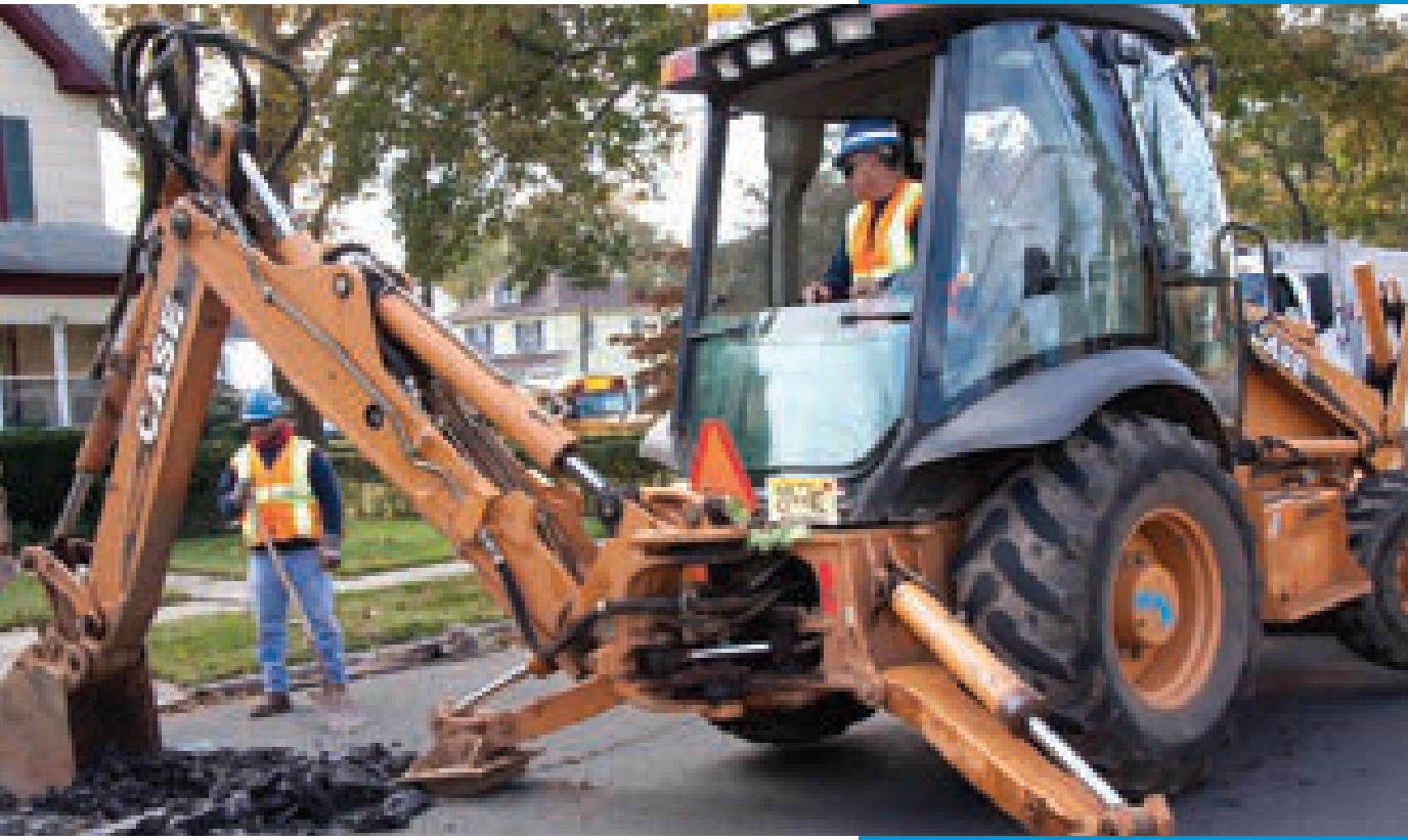 CASE backhoe excavator performing infrastructure repairs on a residential street