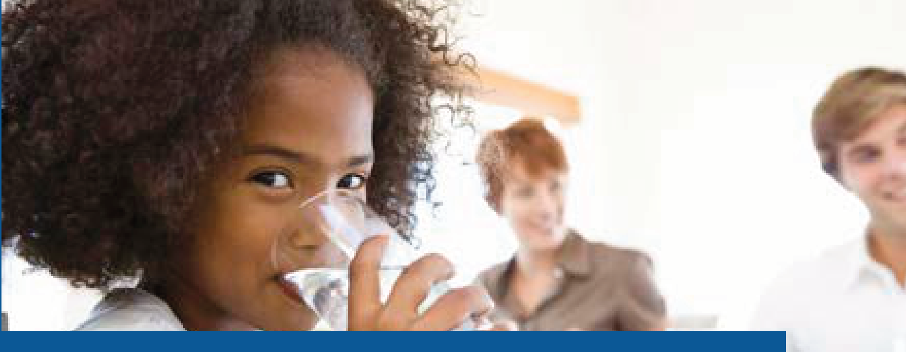 Child enjoying a clean glass of water at a family dining table