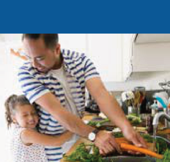 Father and young daughter happily preparing food together in kitchen