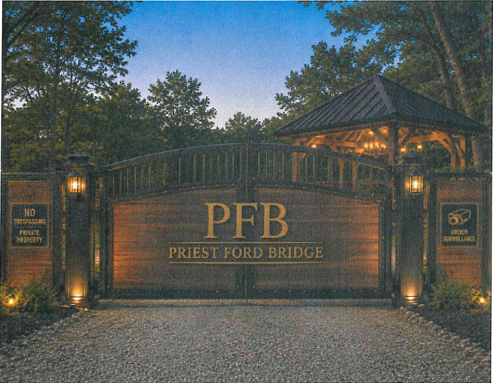 Permanent entrance gate bearing PFB Priest Ford Bridge signage and covered gazebo structure at dusk