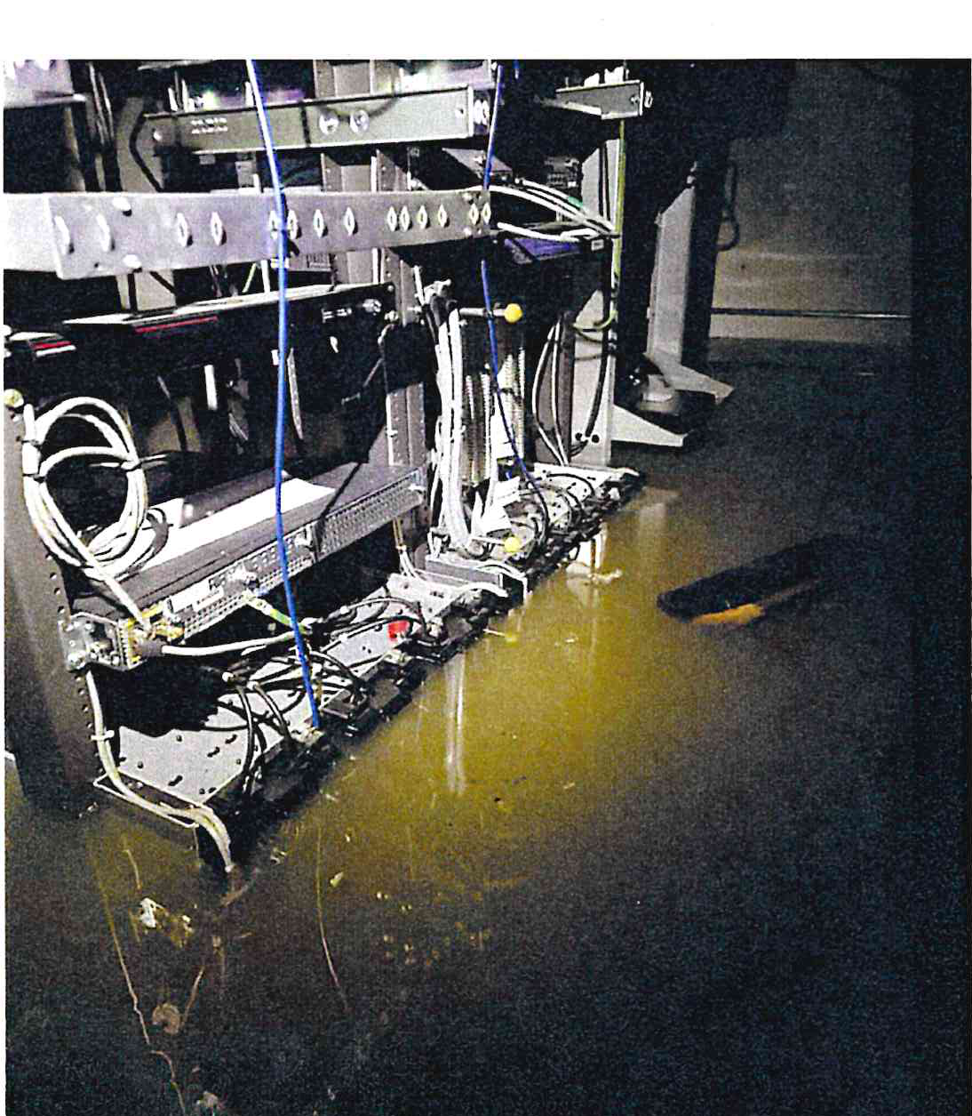 Standing floodwaters covering the floor around communications racks, cabling, and power equipment.