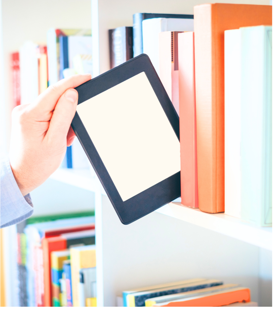Hands holding an e-reader tablet against library bookshelves
